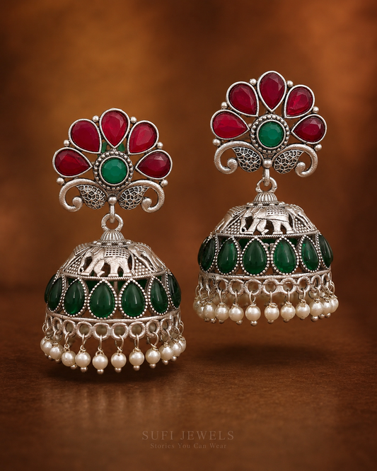 The Flower Kept Dancing silver-look floral dangler earrings with red and green stones and pearl drops.