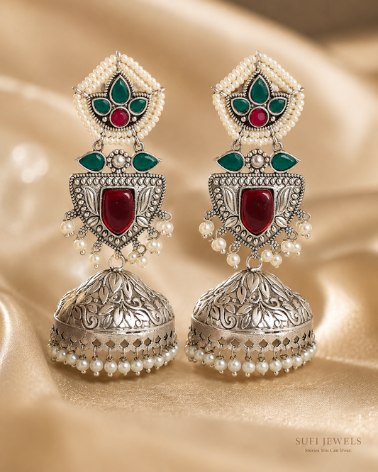 The Ruby Found Shelter silver-look jhumki earrings with red and green stones, sculpted leaves and white pearl drops.