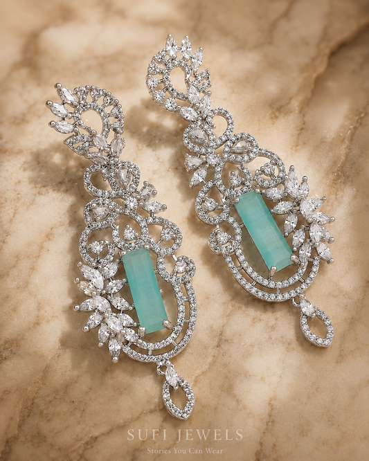 The Stars Learned Shimmer silver dangler earrings with a turquoise centre, crystal-like floral details and vine motifs.